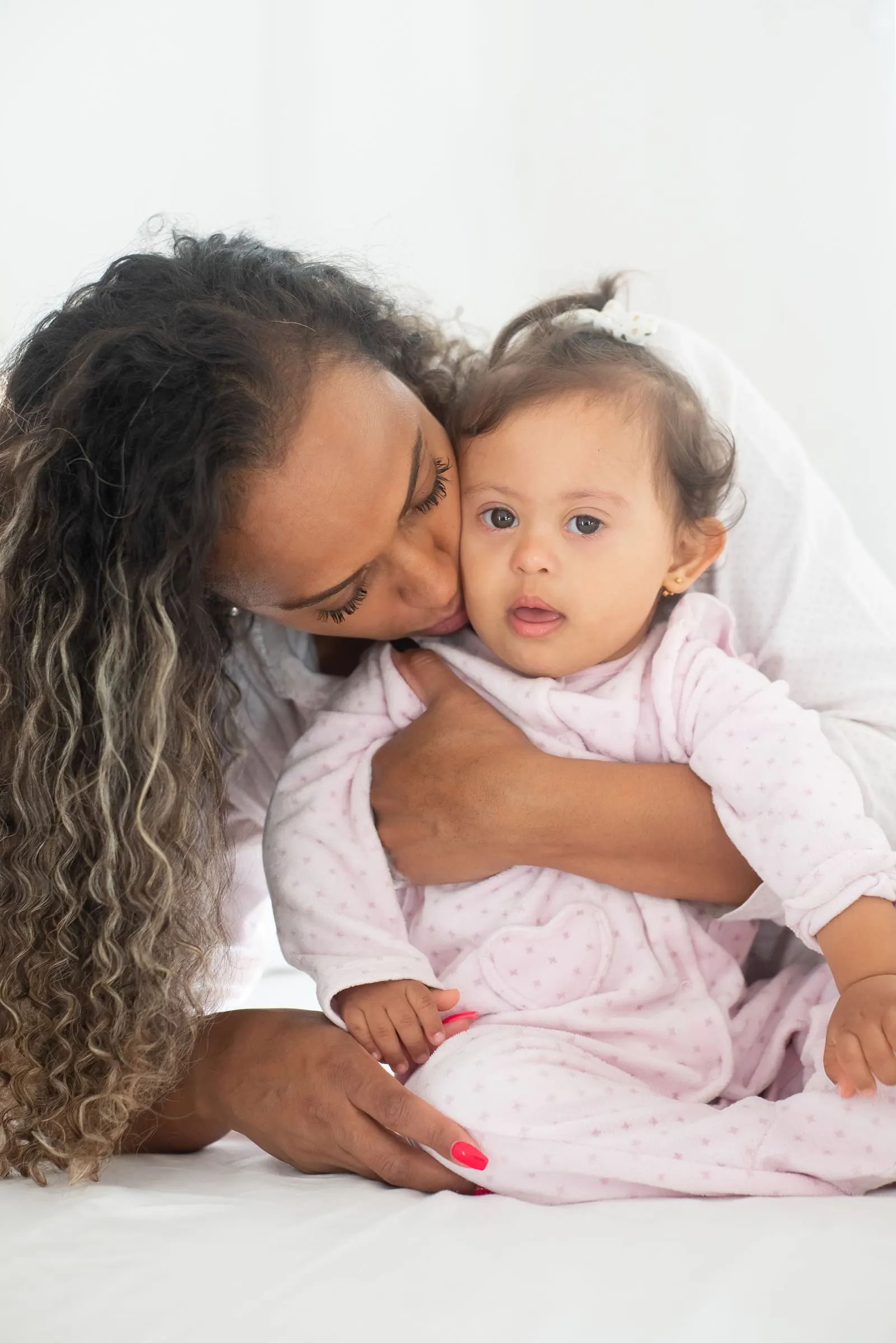 A mother embracing her young daughter with Down syndrome