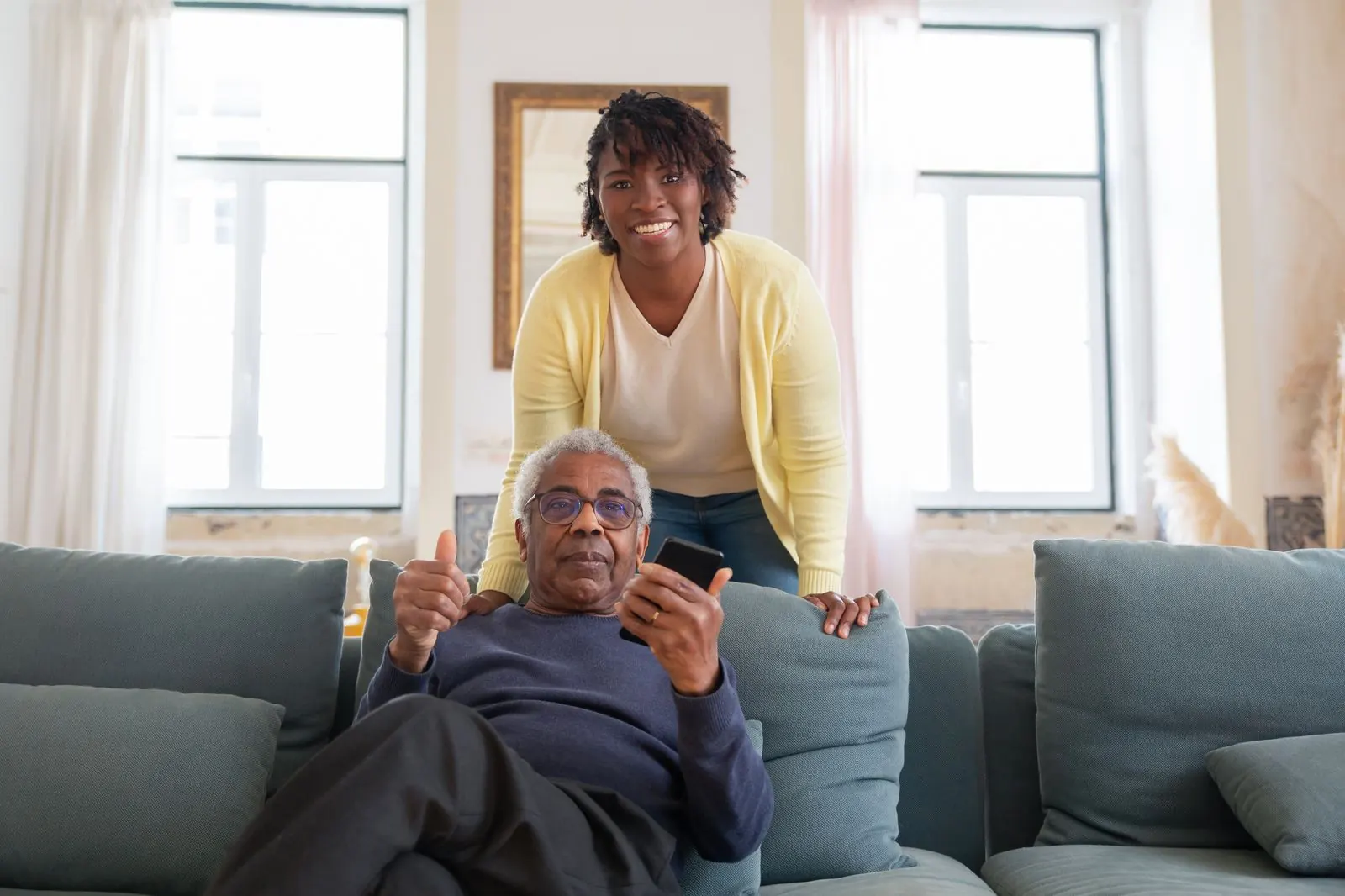 A caregiver visiting an older man in his living room